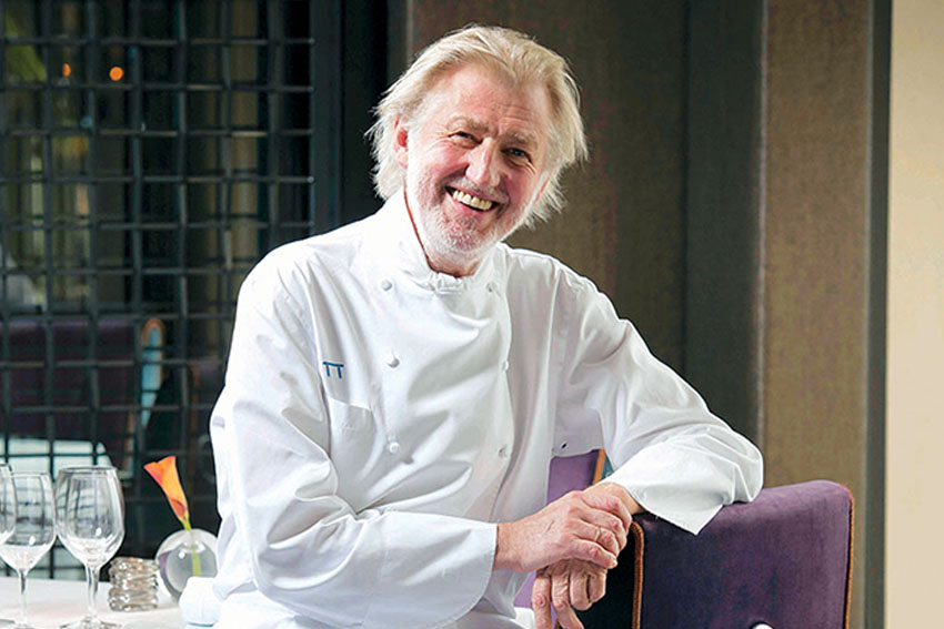 Pierre Gagnaire (14 Michelin Stars) is sitting in his restaurant and smiling